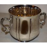 An Edwardian silver porringer, the ogee panelled body with two dolphin scroll handles, 3.75in (9.