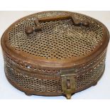 An Oriental brass oval pierced cricket box, the hinged lid with a brass swing handle, a clasp to the