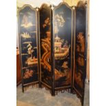 An Oriental style black and gold lacquer four fold screen, decorated figures in a summer palace, the
