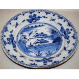 A late eighteenth century Delft large blue and white wall plate, decorated an oriental style scene