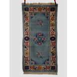 Tianjin rug, north east China, 1930s-40s, 6ft. X 3ft. 1.83m. X 0.91m. Pale blue field with centre