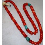 A Tibetan coral bead necklace, interspersed with three pieces of turquoise and a bone toggle, approx