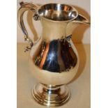 A George III silver baluster wine jug, the scroll spout with a moulded teardrop, a leaf capped