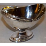 A George III silver oval sugar basket, gilded inside, with a reeded edge and swing handle, on a