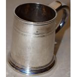 A Queen Anne silver mug, the neck with contemporary pricked initials and a reeded band, a hollow
