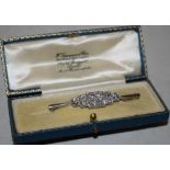 An Art Deco platinum and ten stone diamond bar brooch.