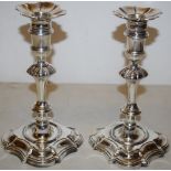 A pair of George II cast silver candlesticks, matching the previous lot, with nozzle extensions,