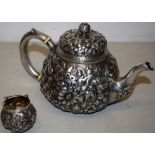 A nineteenth century North American silver teapot, with a repousse chrysanthemum decorated