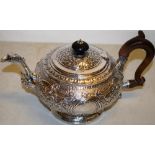 A Regency silver teapot with chased floral scrolls, vacant cartouches, a cast leaf capped mask set