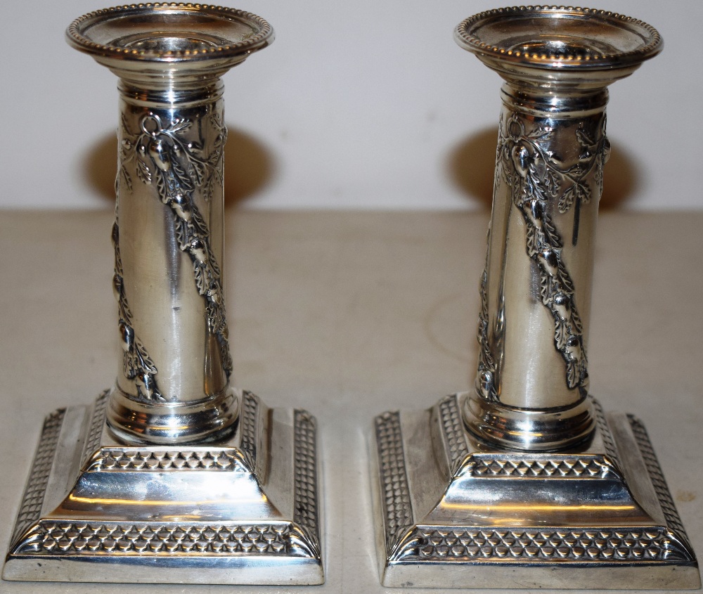 A pair of late Victorian silver boudoir candlesticks, the stems with repousse ribbon tied swags