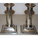 A pair of late Victorian silver boudoir candlesticks, the stems with repousse ribbon tied swags