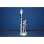 A Lladro figure of a man lighting the street lamp