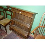 A wall-hanging Oak plate-rack with two shelves and moulded pediment/frieze.