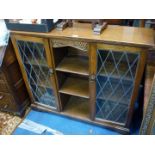 An Oak floor standing book-shelves/cabinet, having a pair of opposing lattice lead-glazed doors.