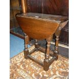 An Oak extending drop-leaf swivel-top Occasional Table on turned legs with perimeter stretchers.