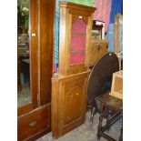 A medium Oak corner cabinet on cupboard having arched glazing to the upper portion and echoed by