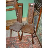 A pair of dark-wood spinning Chairs having Bulrush and abstract details in relief to the back rests.