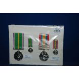 Two commemorative Medals with their miniatures "For Service" and "The Cold War" against