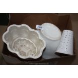 Two large jelly moulds and a kitchen sieve/strainer.