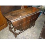 A very heavy Oak gate-leg drop-leaf dining Table, having turned legs and a drawer to one end,