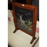 A Mahogany framed firescreen with needlework depiction of a Stag in the Highlands amidst rocky