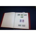 A red stamp album of Channel Islands stamps.