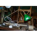 A Brass desk Lamp with green glass shade.