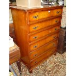 A satinwood tallboy of 6 short drawers with brass backplate drop handles, standing on bracket feet.