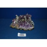 A piece of amethyst cluster having small figures chipping away