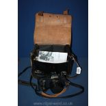 A Canon T50 35mm camera with 50mm 1.8 FD lens, flashgun, eye piece and leather bag.