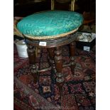An Edwardian screw pillar adjustable Piano Stool having turned legs, the turquoise upholstered seat,