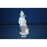 A Lladro figure of a Boy dressed for winter with his dog.