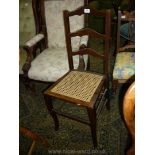 A cane seated dark-wood framed ladder-back bedroom Chair.