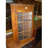 An attractive wall hanging Cabinet having nine pane glazed door and dentil frieze,