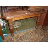 An Edwardian Mahogany wind-out Dining Table having canted corners and standing on turned and reeded