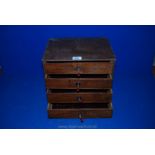 A small four-drawer wooden table top Cabinet with velvet lined drawers.