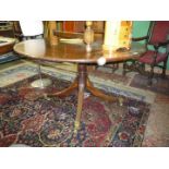 A circular mixed woods extending Dining Table having turned central pillar with four splay reeded