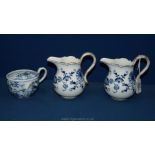 Three pieces of Meissen including two cream jugs and a sideways cup (1850-1924).