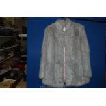 A genuine fur jacket in grey, size 14.