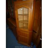 An attractive matt finished Oak Corner Cabinet over Cupboard with fluted and carved details,