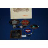 A quantity of car badges including; a Rolls Royce owners club, plaque and enamel badge,