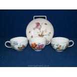 Three Meissen cups and a saucer decorated with buds and flowers.