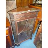 A Mahogany floor standing Corner Cabinet having blind fretwork detail and standing on bracket feet,