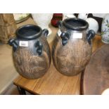 Two large brown Australian vases with four handles.