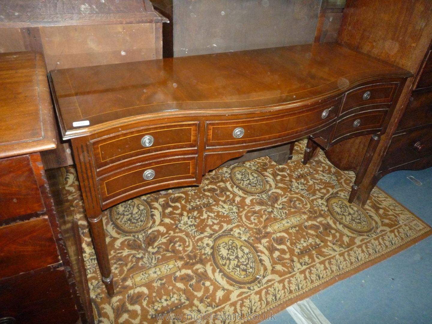 A reproduction cross-banded Mahogany Sideboard having one long and four short drawers and standing