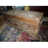 A camphorwood Chest profusely carved, depicting scenes of buildings and bridges over a river,
