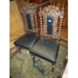 A pair of carved Oak framed Hall Chairs having top rails incorporating a crown,