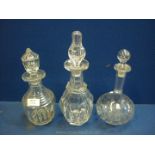Three glass decanters with stoppers.