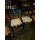 A pair of stylised ebonised framed Side Chairs having woven string seats