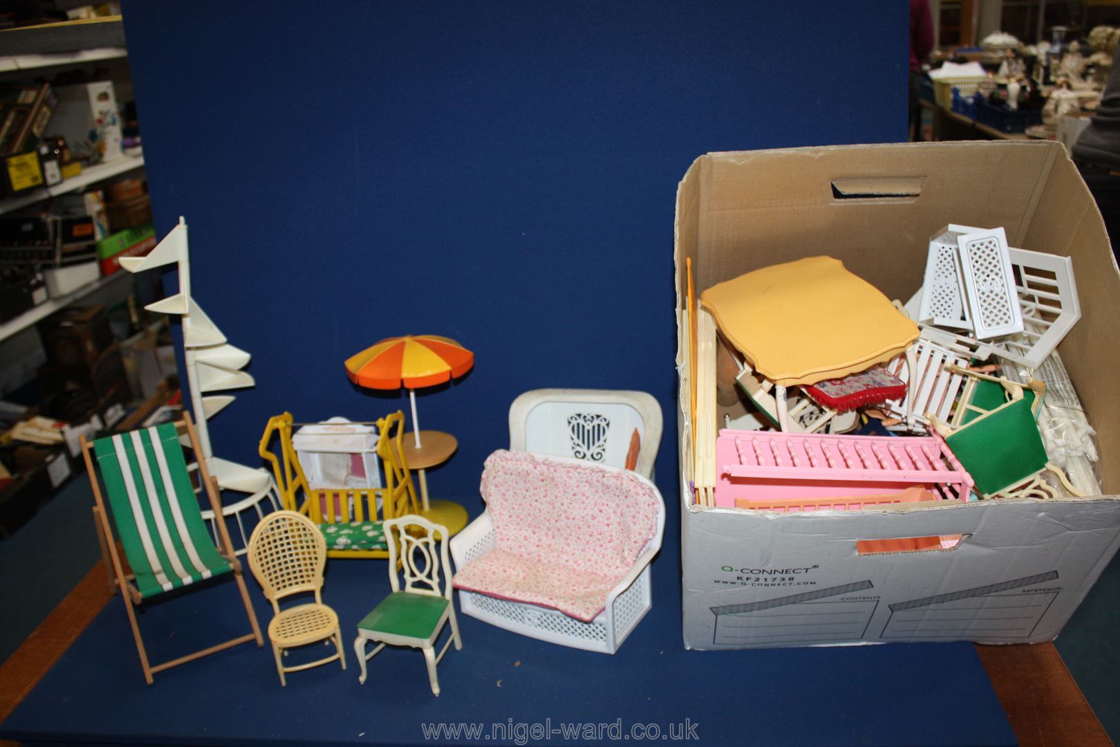 A box of miscellaneous Sindy accessories including garden chair, exercise bike, high chair, dogs,